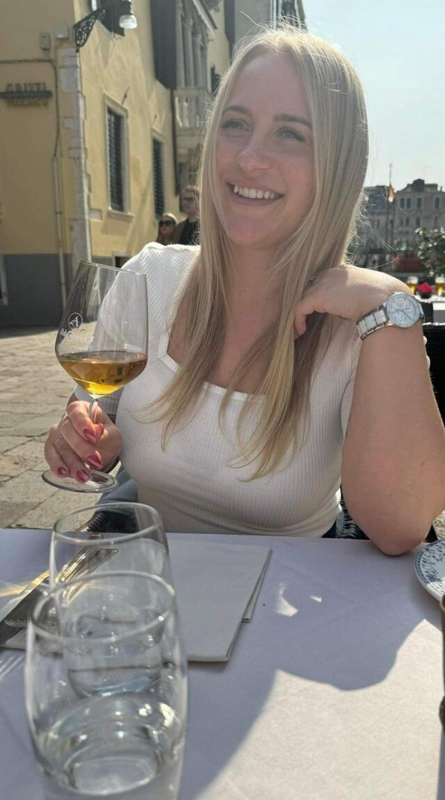Michaela se sklenkou vína na slunné terase